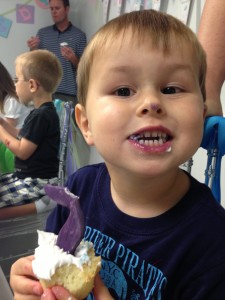 Liam enjoys a purple mermaid tail cupcake, as does the tip of his nose.