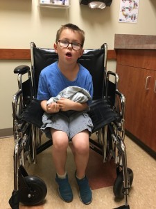 At the urgent care - I was lifting him everywhere but it was hurting my back, so our hero got to ride in a wheelchair, which thrilled him to no end.